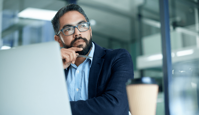 man thinking at computer in office