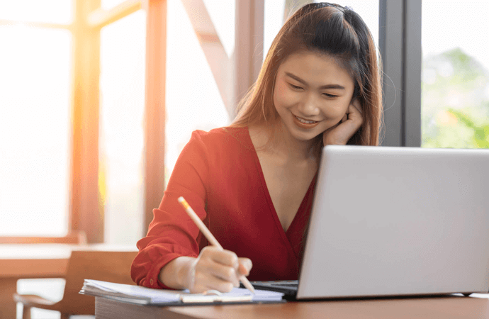Woman on laptop with paper