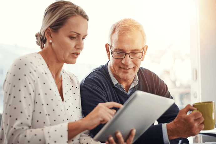 man and woman looking at tablet together
