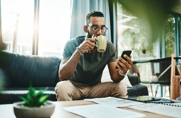 Man on phone sipping coffee
