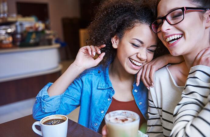 Happy young female couple at coffee shop