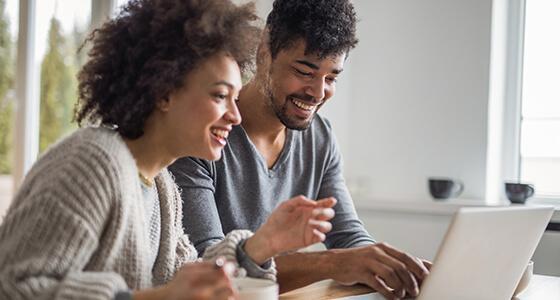Young couple reading laptop