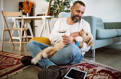 Man with tablet holding his dog