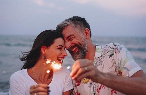 Couple on the beach holding sparklers