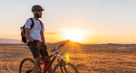Man on a mountain bike watching the sunset