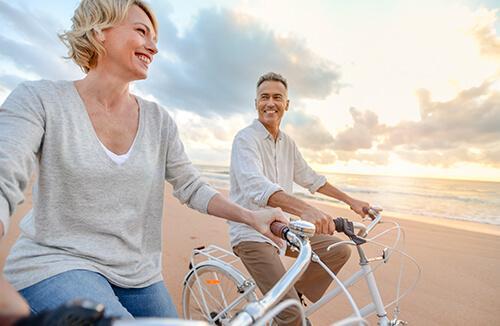 A couple riding bikes on the beach