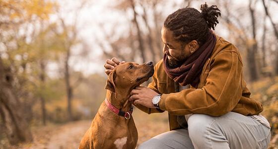 A man petting his dog outside