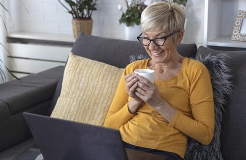 Woman on couch viewing laptop