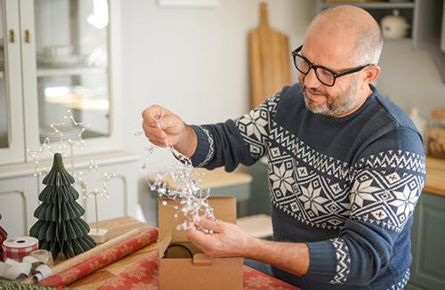 Man wrapping holiday gifts