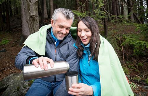 Couple outdoors enjoying a hot beverage