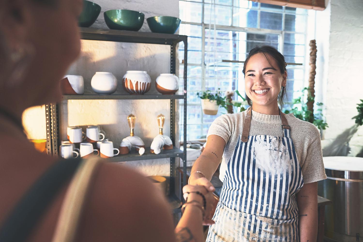 People shaking hands in pottery studio