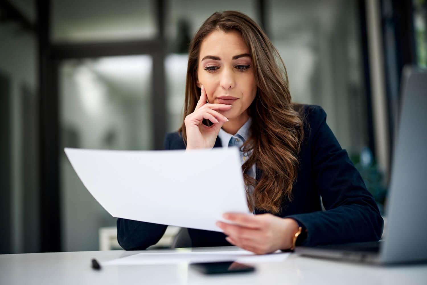 Woman with paper and laptop